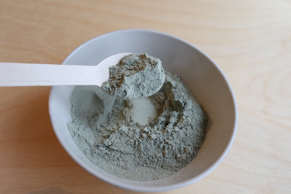 Close-up,Of,A,Bowl,Of,Green,Clay,With,A,Wooden Close-up,Of,A,Bowl,Of,Green,Clay,With,A,Wooden