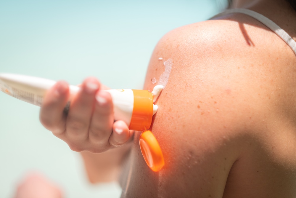 Woman,Applies,Sunscreen,To,Her,Arm,Outdoors,,Using,Orange,Tube, Woman,Applies,Sunscreen,To,Her,Arm,Outdoors,,Using,Orange,Tube,