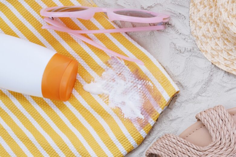 Spilled,Sunscreen,On,Beach,Towel,Or,Or,A,Swimsuit.,Concept
