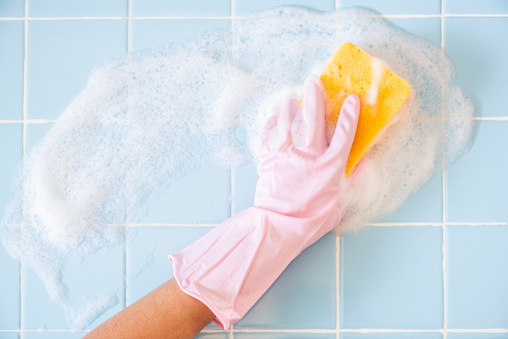 A,Hand,In,A,Pink,Glove,Scrubs,Soapy,Tiles,With