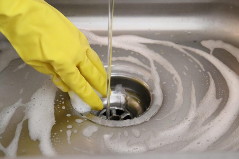 Woman,Hand,In,Yellow,Glove,Holding,A,Sponge,In,A