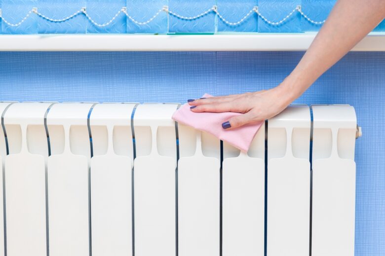 Woman,Removes,Dust,From,A,Heating,Radiator.,Woman,Cleaning,The