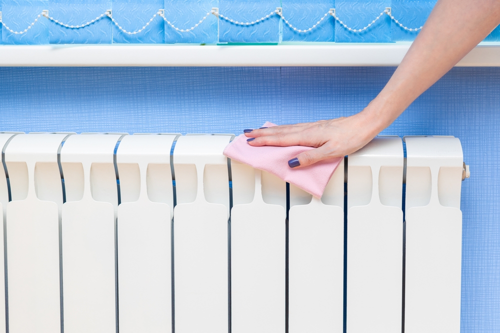 Woman,Removes,Dust,From,A,Heating,Radiator.,Woman,Cleaning,The Woman,Removes,Dust,From,A,Heating,Radiator.,Woman,Cleaning,The