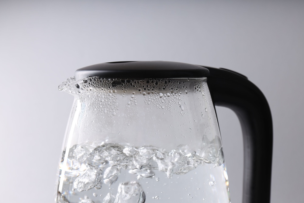 Water,Boiling,In,Electric,Kettle,On,Light,Grey,Background,,Closeup Water,Boiling,In,Electric,Kettle,On,Light,Grey,Background,,Closeup