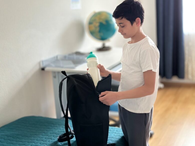 The,Boy,Is,Packing,His,Backpack,In,The,Children's,Room.