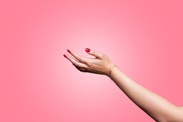 A,Young,Woman's,Hand,Reaching,Out,To,Accept,Something,With