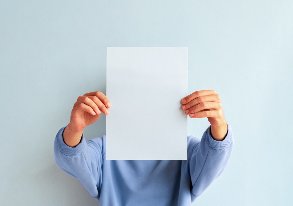 Man,Covering,His,Face,With,Blank,Blue,Sheet,Of,Paper. Man,Covering,His,Face,With,Blank,Blue,Sheet,Of,Paper.