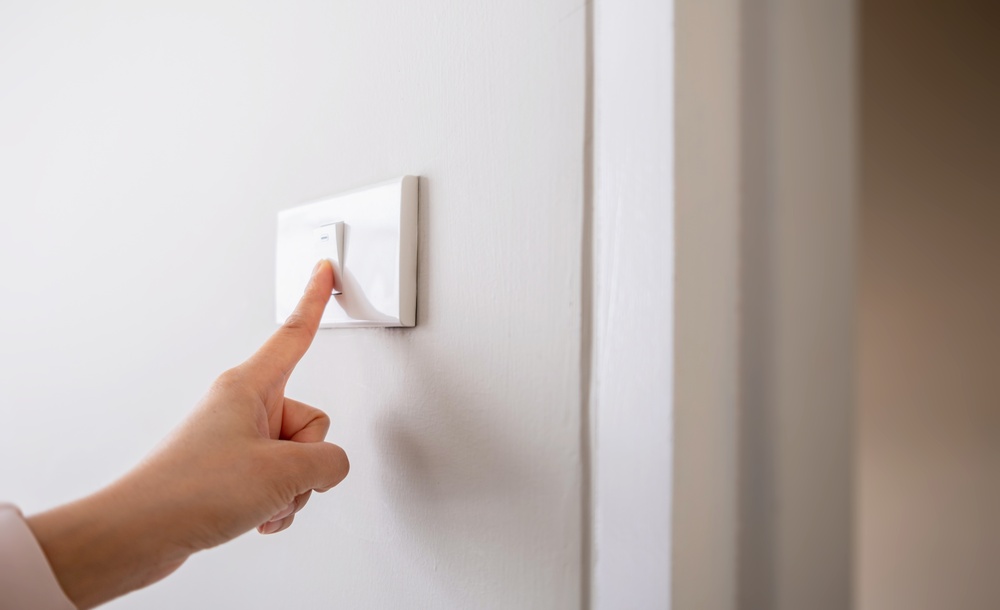 Close-up,Of,A,Hand,Turning,Off,Light,Switch,On,Wall. Close-up,Of,A,Hand,Turning,Off,Light,Switch,On,Wall.