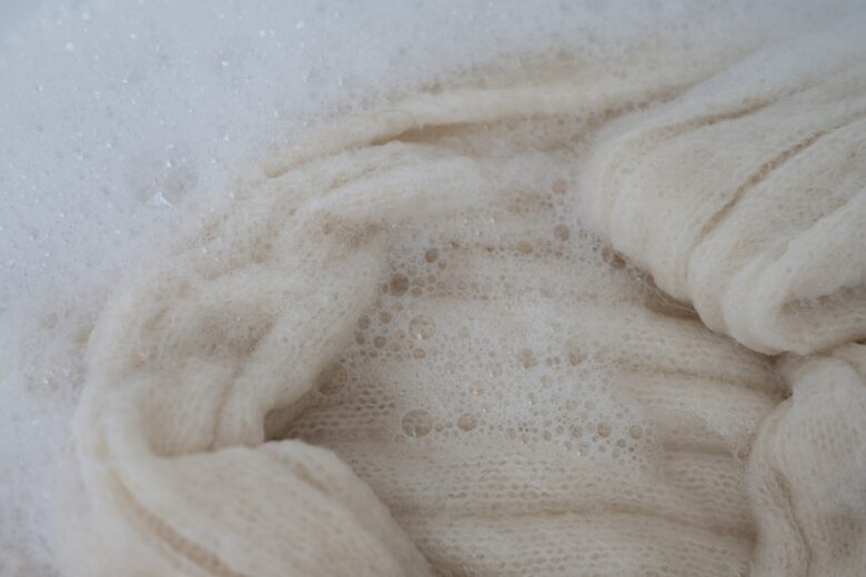 Close,Up,Of,White,Wool,Sweater,Being,Soaked,Before,Handwashing