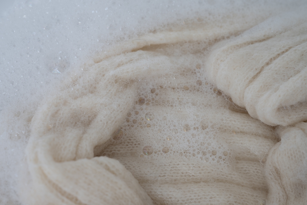 Close,Up,Of,White,Wool,Sweater,Being,Soaked,Before,Handwashing Close,Up,Of,White,Wool,Sweater,Being,Soaked,Before,Handwashing