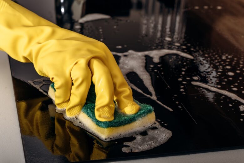 Kitchen,Cleaning,With,Rubber,Gloves,Spraying,Cleaner,On,Glass,Induction