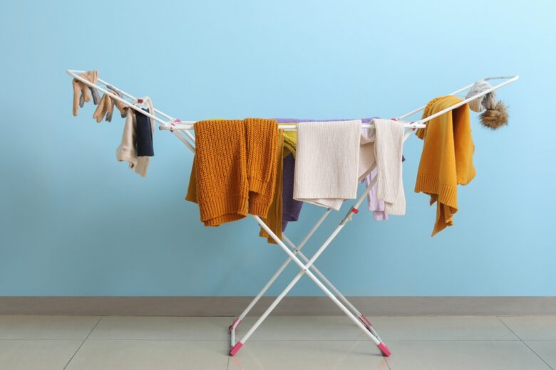 Clean,Winter,Clothes,Hanging,On,Dryer,Near,Blue,Wall