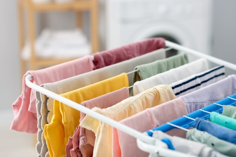 Many,Clean,Baby,Clothes,On,Drying,Rack,Indoors,,Closeup