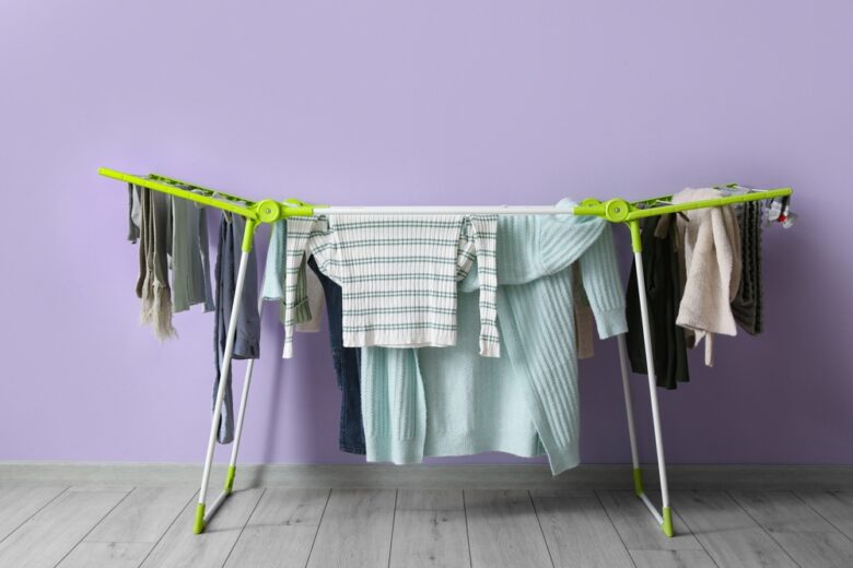 Dryer,With,Winter,Clothes,On,Floor,Near,Purple,Wall