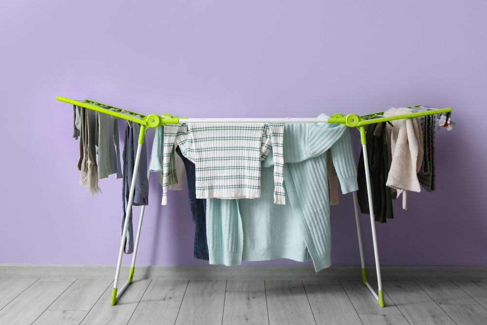Dryer,With,Winter,Clothes,On,Floor,Near,Purple,Wall Dryer,With,Winter,Clothes,On,Floor,Near,Purple,Wall
